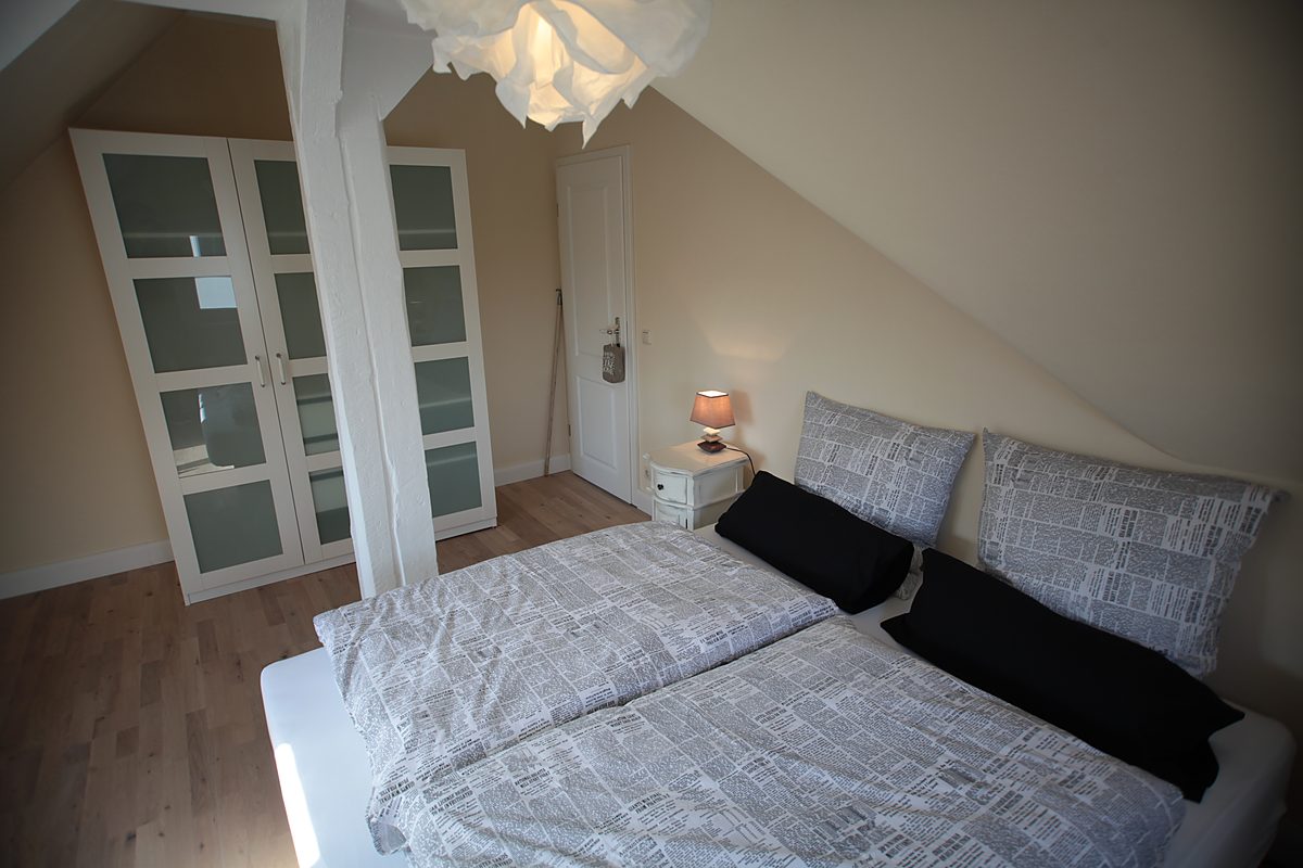 Möbliertes Schlafzimmer der Atelierwohnung im Dachgeschoss der Villa Emmilio