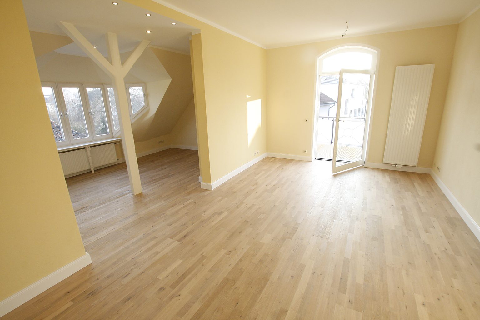 Heller Wohnraum mit Dachschräge in der leeren Atelierwohnung der Villa Emmilio