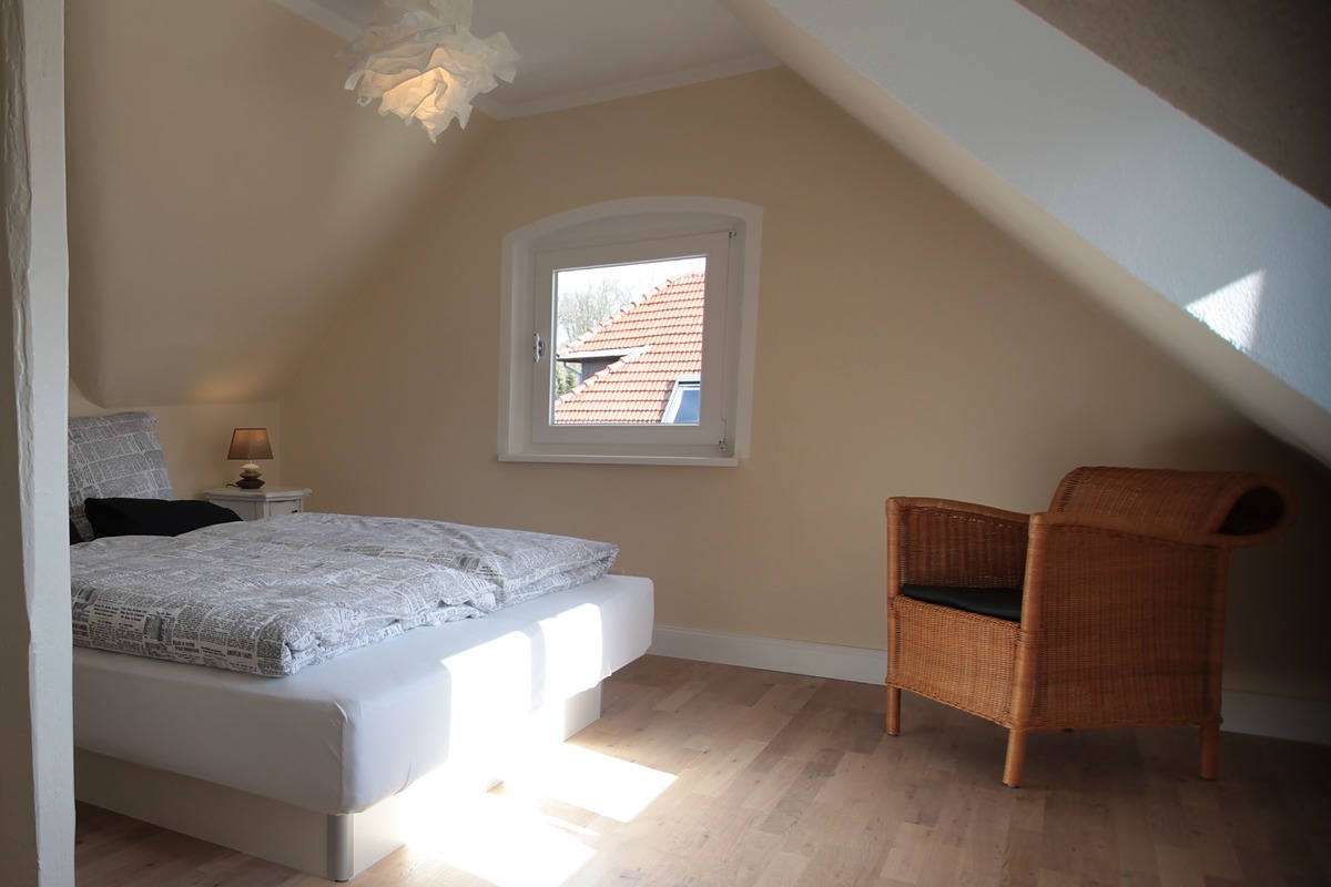 Gaube und Dachschräge im Schlafzimmer der Atelierwohnung der Villa Emmilio