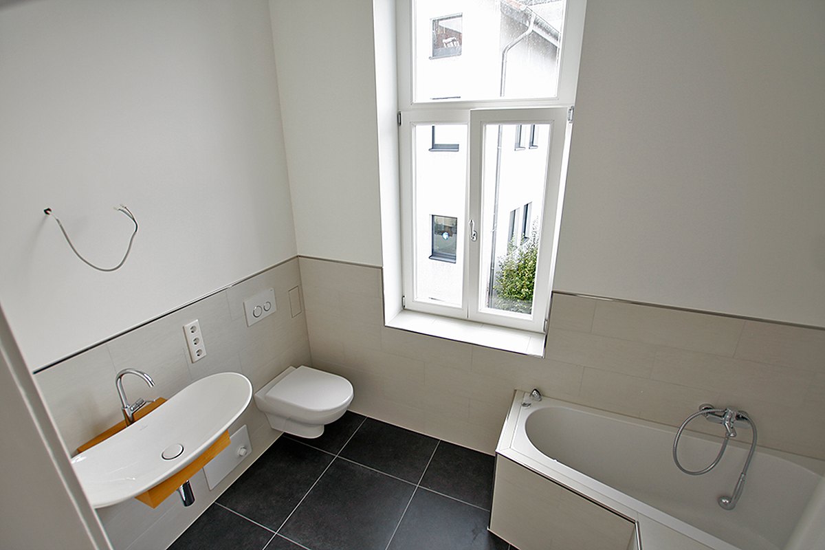 Badezimmer der leeren Bel-Étage-Wohnung mit Badewanne