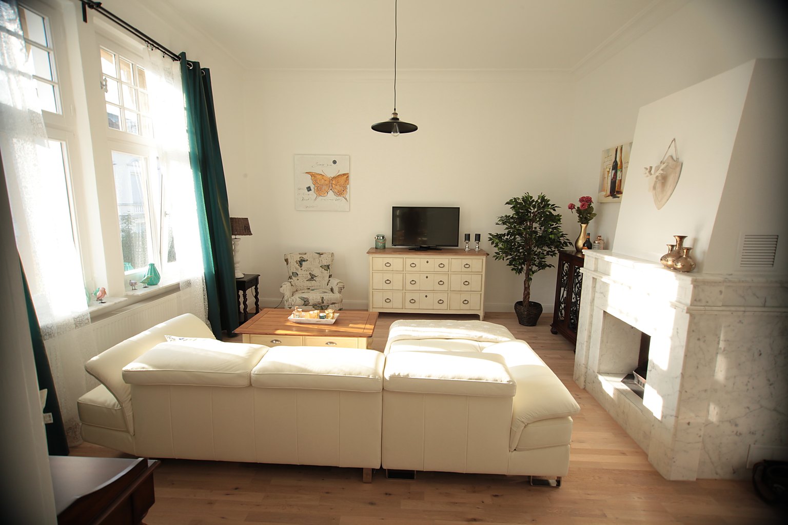 Möbliertes Wohnzimmer der Bel-Étage-Wohnung mit Kamin und hochwertigen Designermöbeln