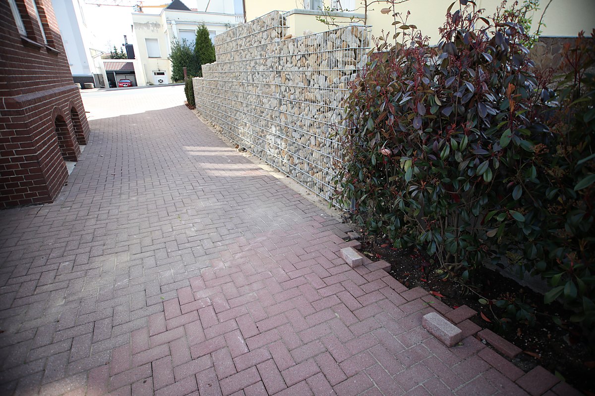 Eigener gepflasterter Hof der Villa Emmilio mit drei Stellplätzen für das Office und Gabionenwand