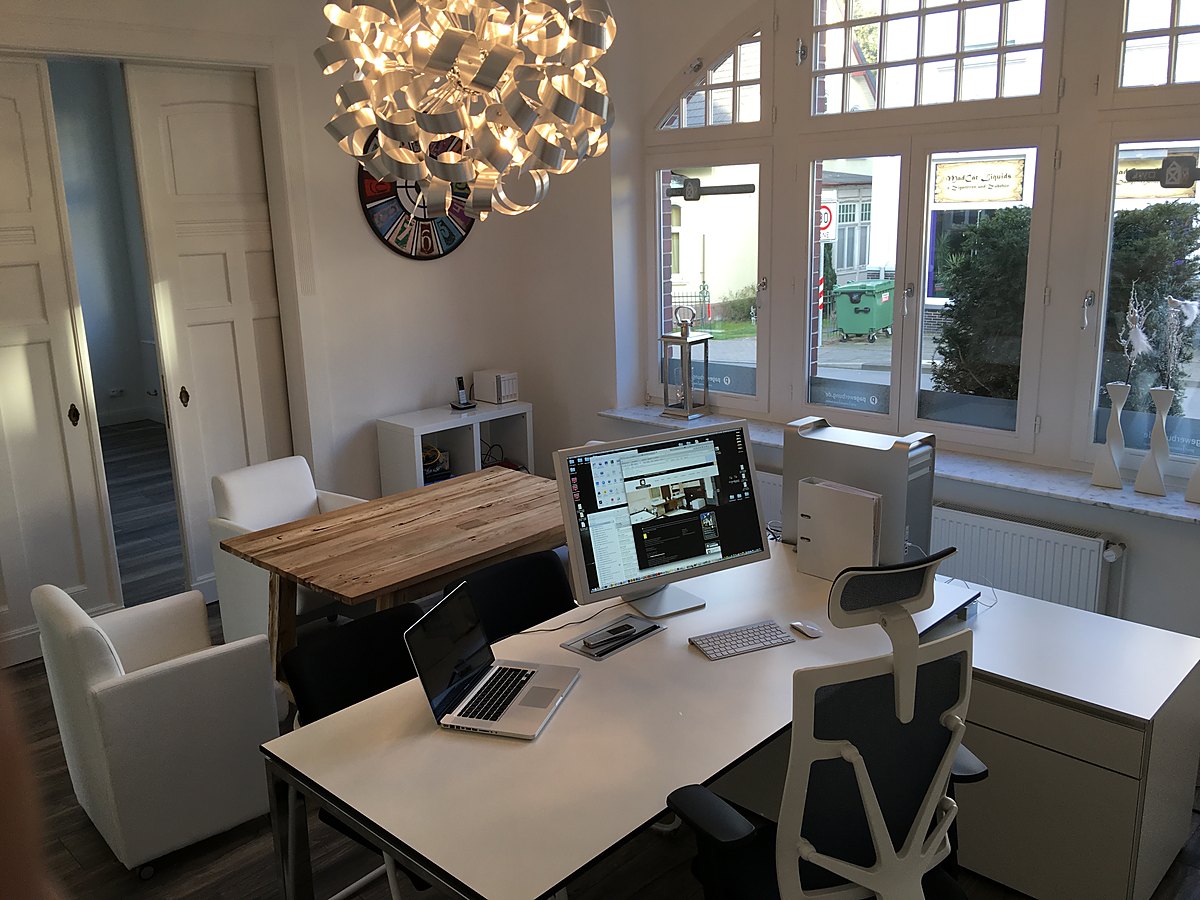 Als Büro eingerichteter Raum mit Arbeitsplätzen und Mac im Hochparterre der Villa Emmilio