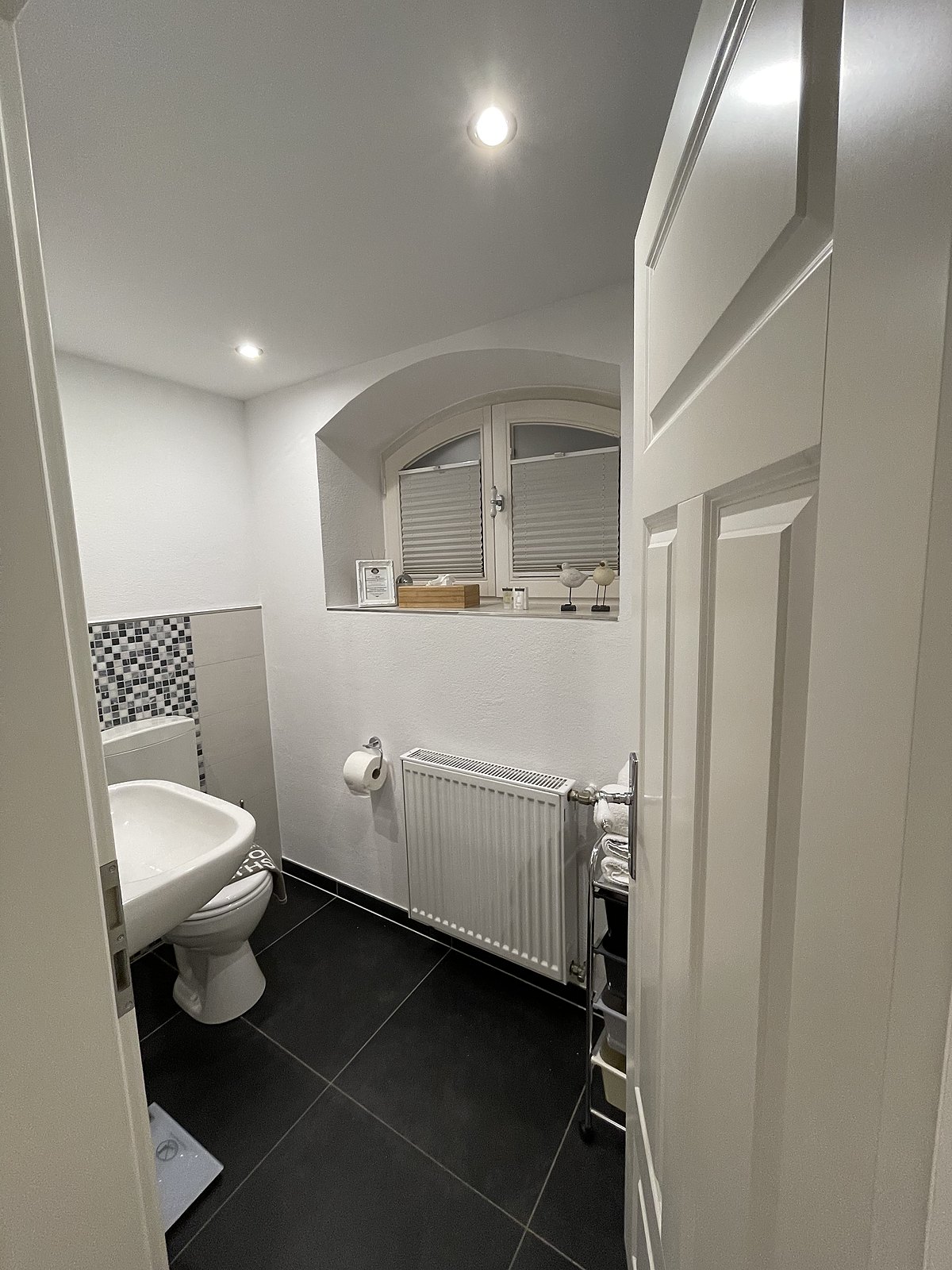 Badezimmer der Souterrain-Wohnung mit Mosaikfliesen
