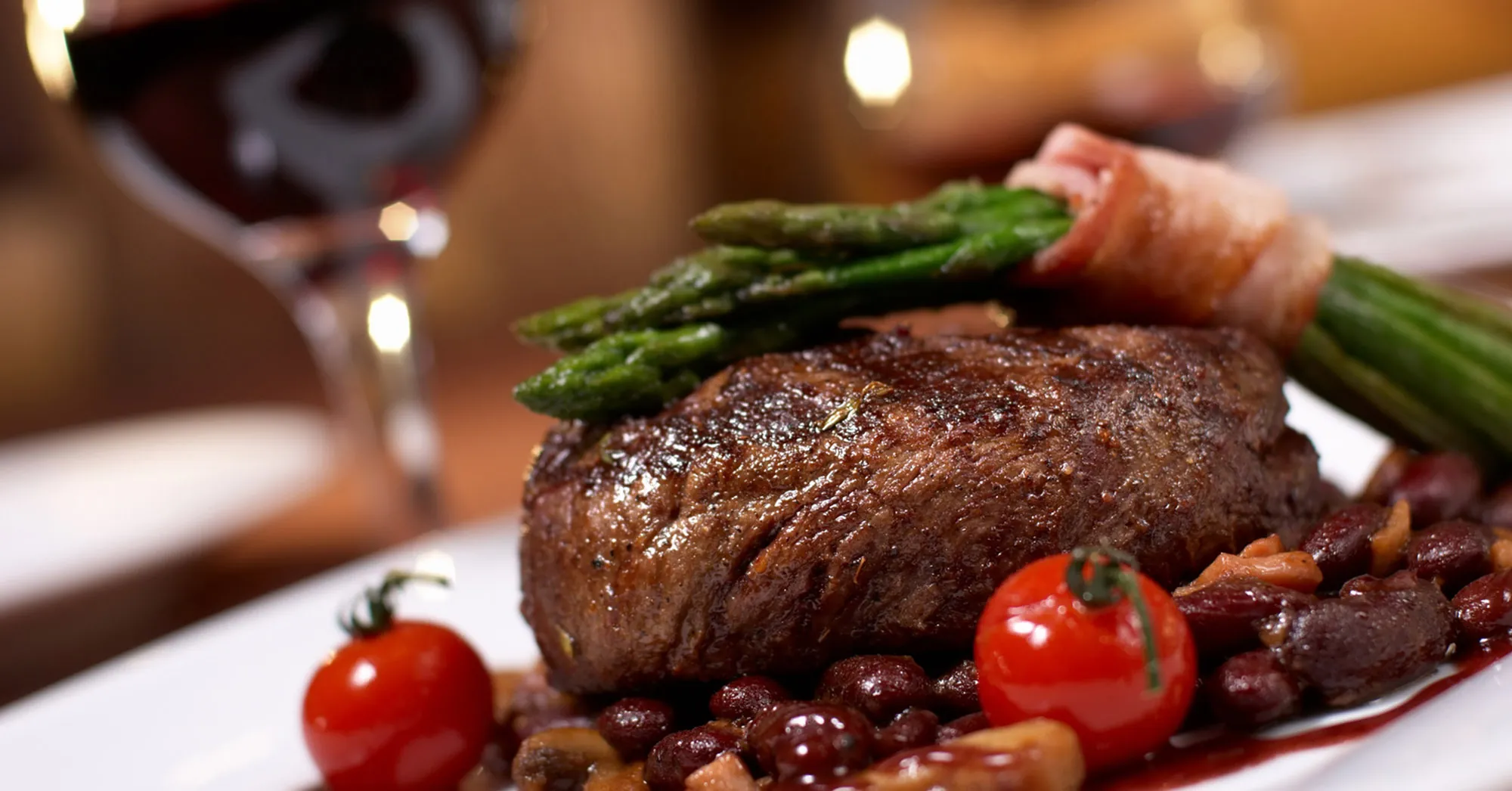 Saftiges Filetsteak mit Spargel im Speckmantel und Rotwein