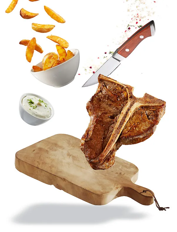 T-Bone Steak mit Kartoffelecken und Dip als Freisteller